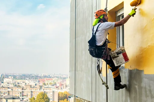 Rope-access painter working on a tall commercial wall in the west Valley